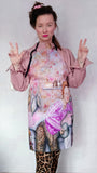 Artist Katrin Valgemäe posing with the “Kitchen” apron, showcasing its vibrant and personal design inspired by her allegorical self-portrait