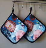 Two pot holders with the “Pervert in the Kitchen” print by Katrin Valgemäe, featuring a heat-resistant cotton-polyester blend