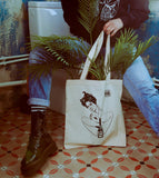 Close-up of the model with the “Male Tears” Natural Tote Bag, showcasing its comfortable fit and bold design in a real-world setting