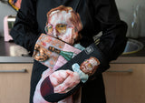 The “Pervert in the Kitchen” oven glove in use, highlighting its artistic design and practical functionality